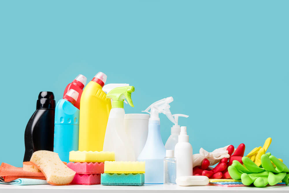 a set of cleaning materials against a blue-green background
